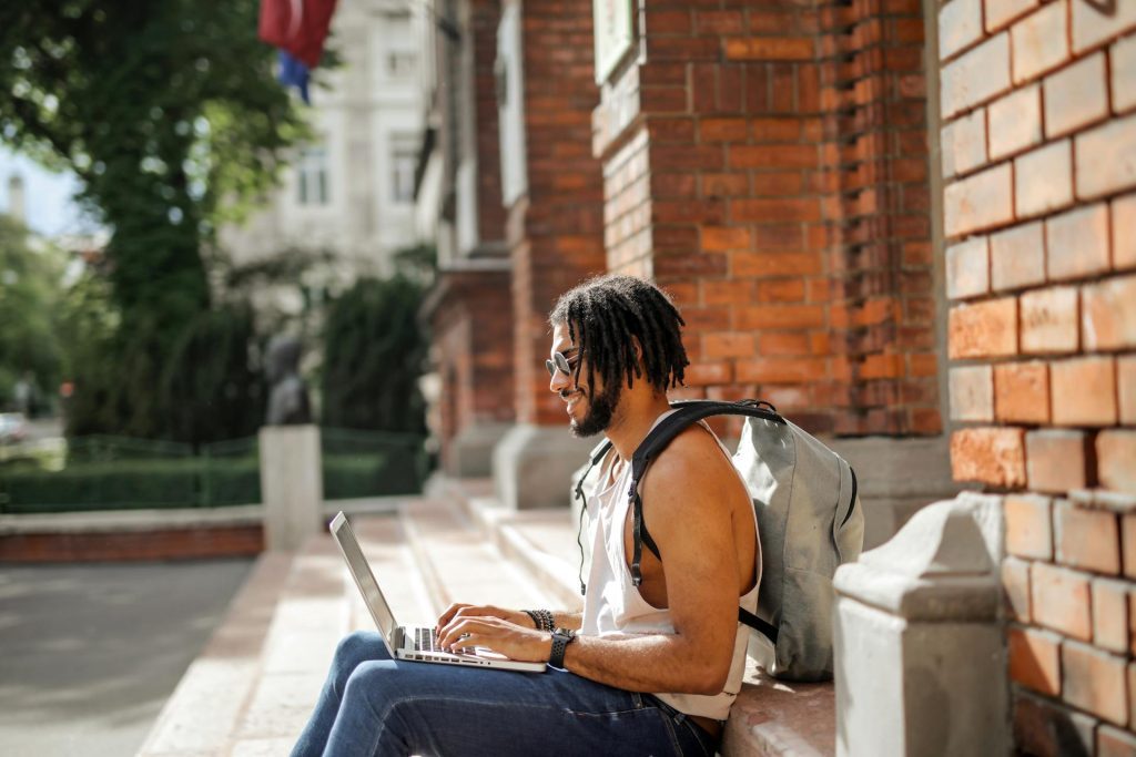Man, wearing sunglasses, using a laptop