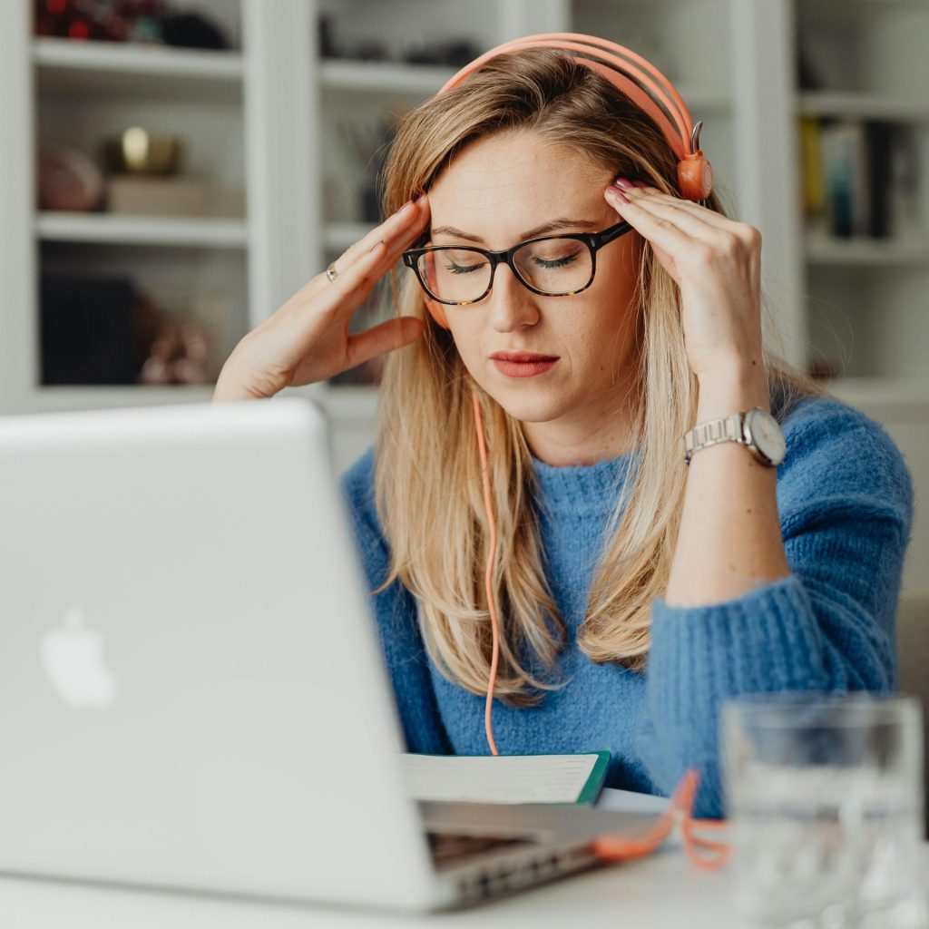 Woman rubs her temples, eyes closed
