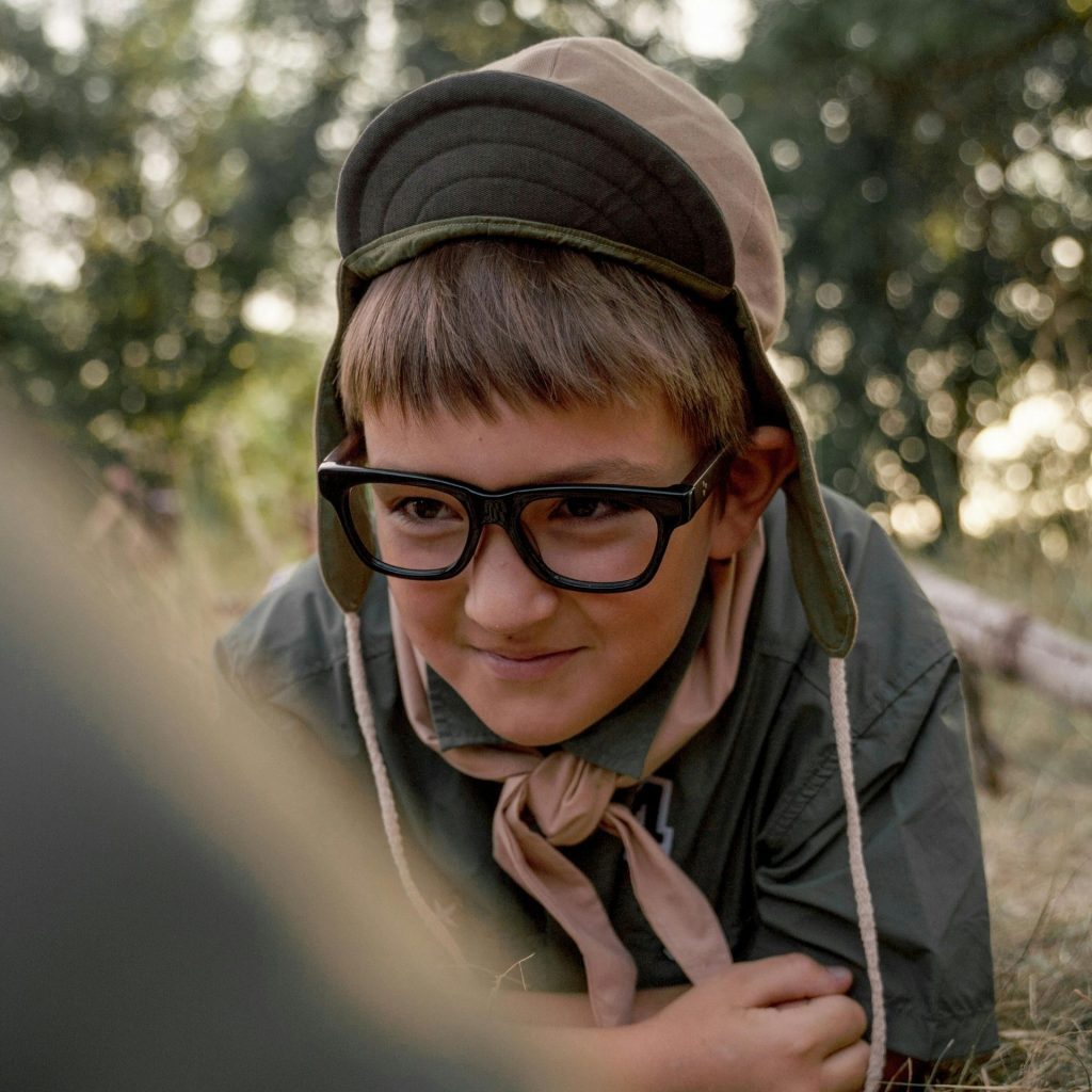 A Child wearing eyeglasses on grass