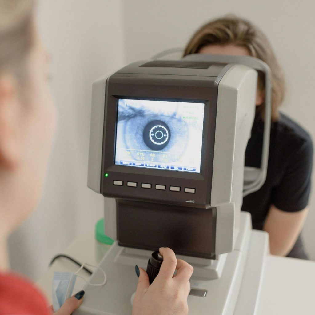 A woman gets her eyes screened by a doctor