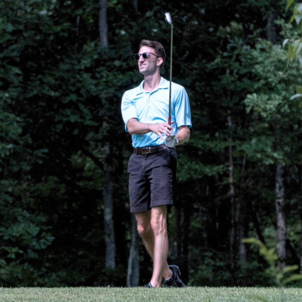 Man playing golf wearing golfing sunglasses