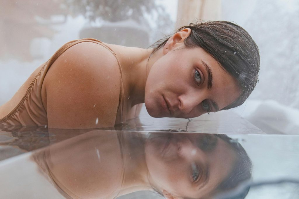 Image of a gray-eyed woman reflected by water