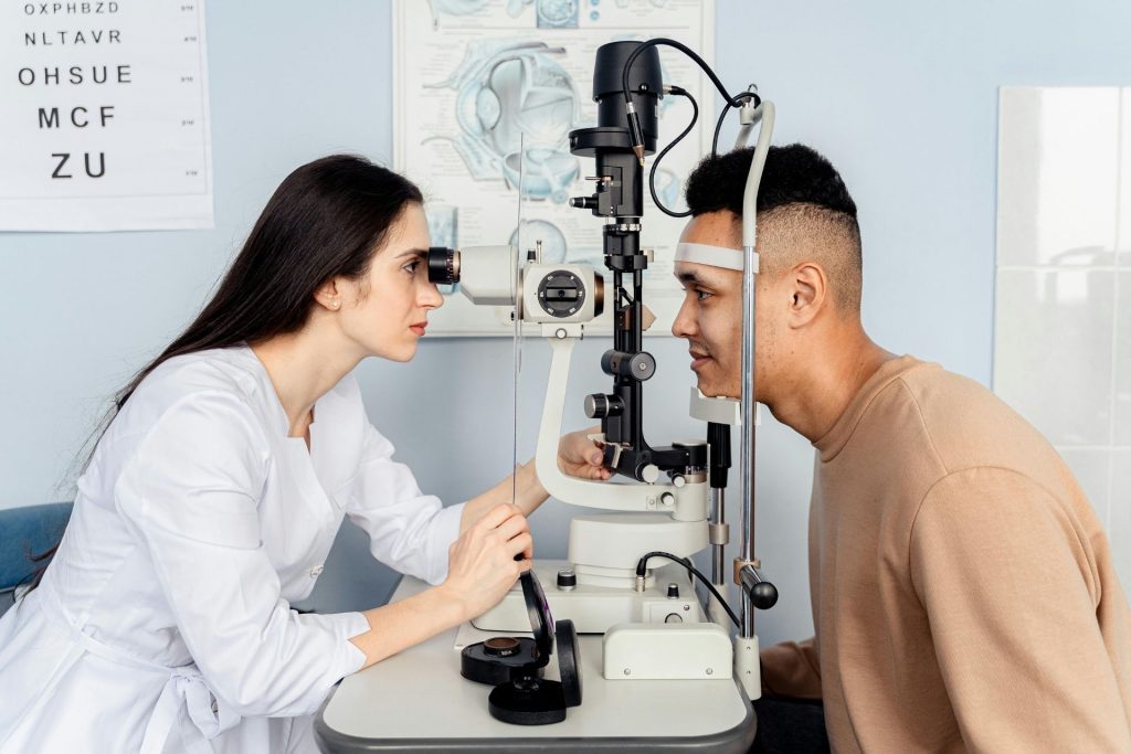 Doctor examining man's vision using auto-refractor