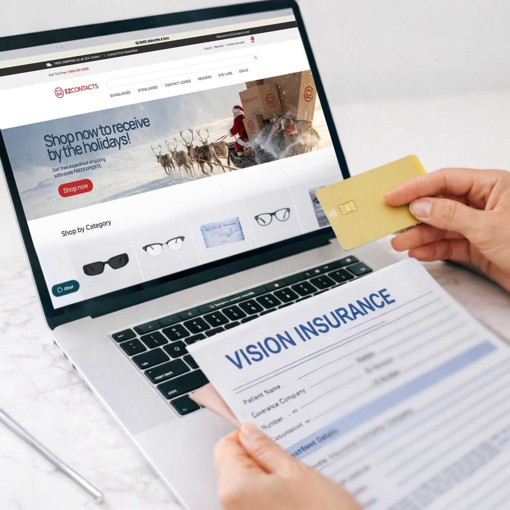 A person browses online while holding her credit card and vision insurance contract