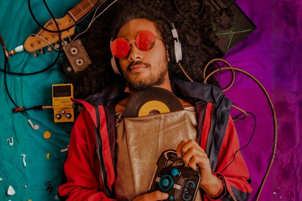 Man listens to music while wearing red sunglasses