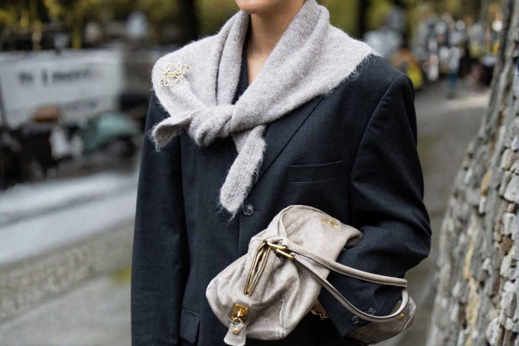 Woman wearing a grey knit triangle scarf