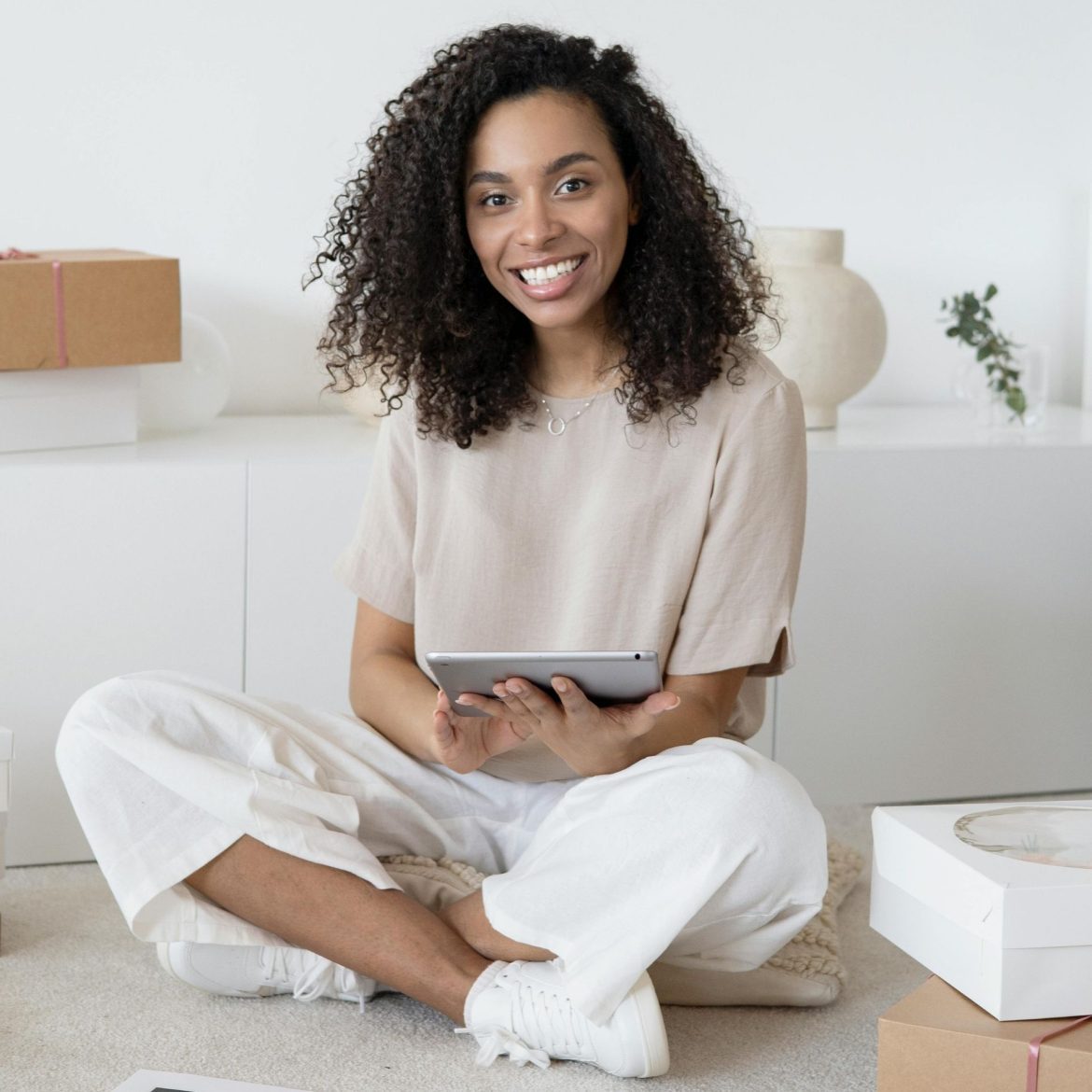 A young woman sits on the floor and looks up from reading her notes