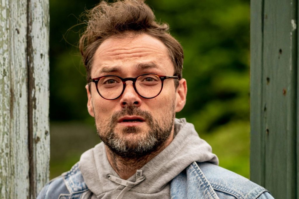Man wearing round horn-rimmed glasses