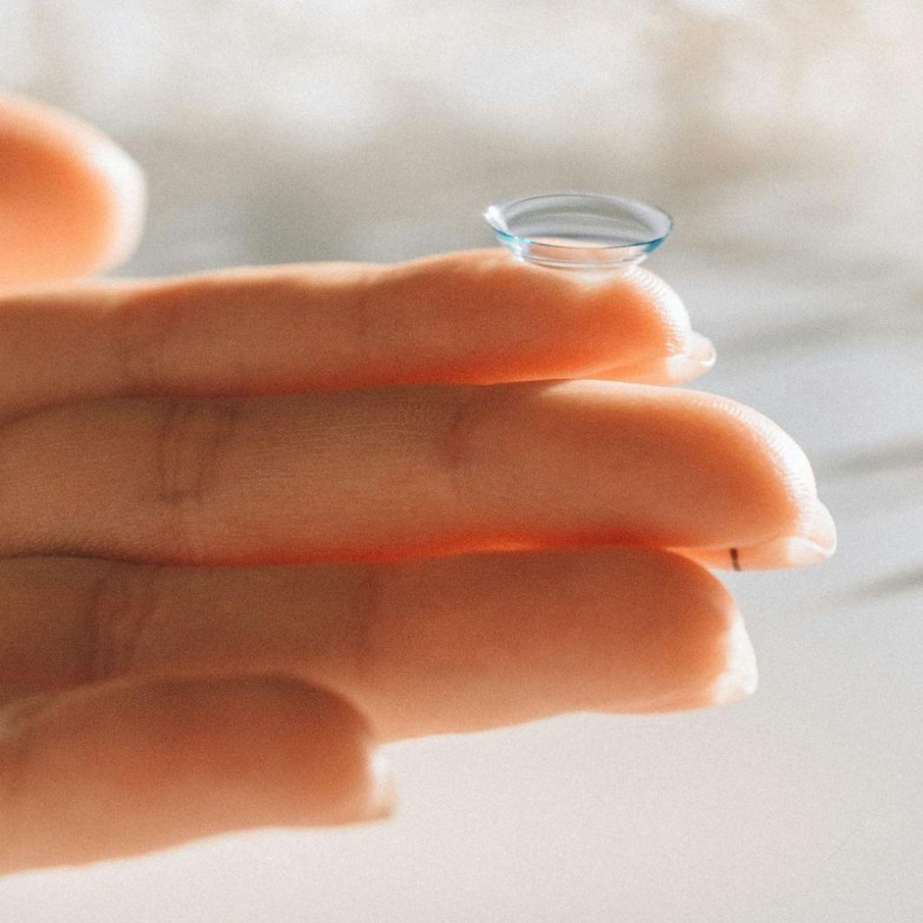 Person holds a contact lens on their finger
