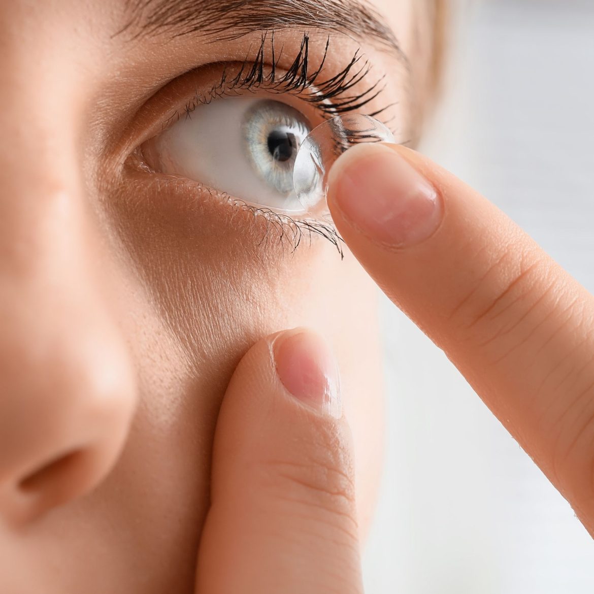 Close-up of a woman putting a contat lens in her eye