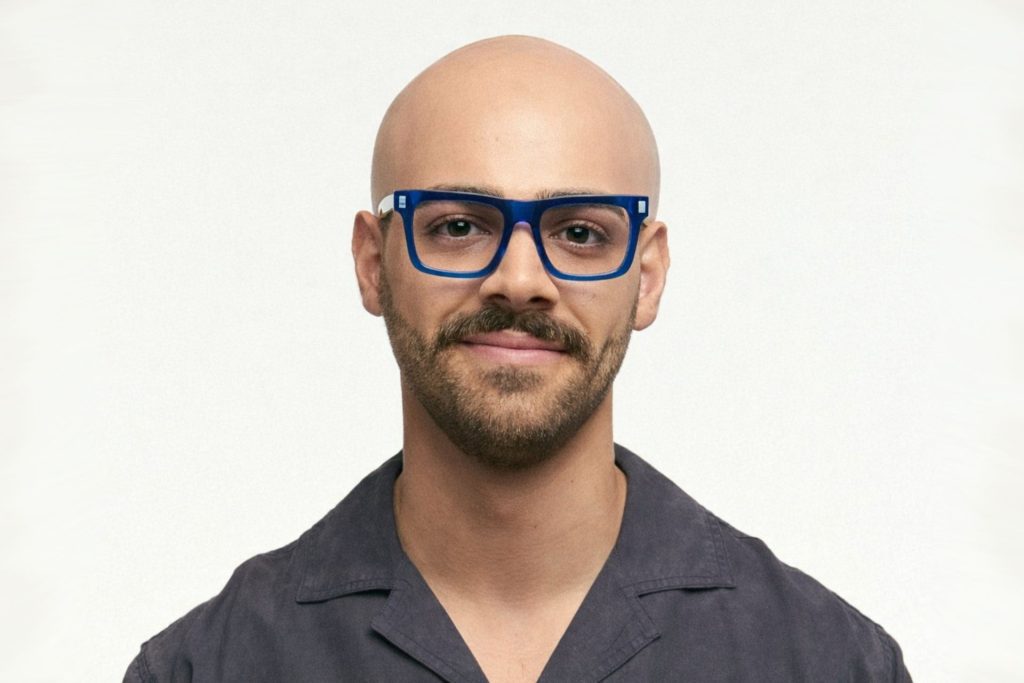 Bald man wearing oversized blue glasses