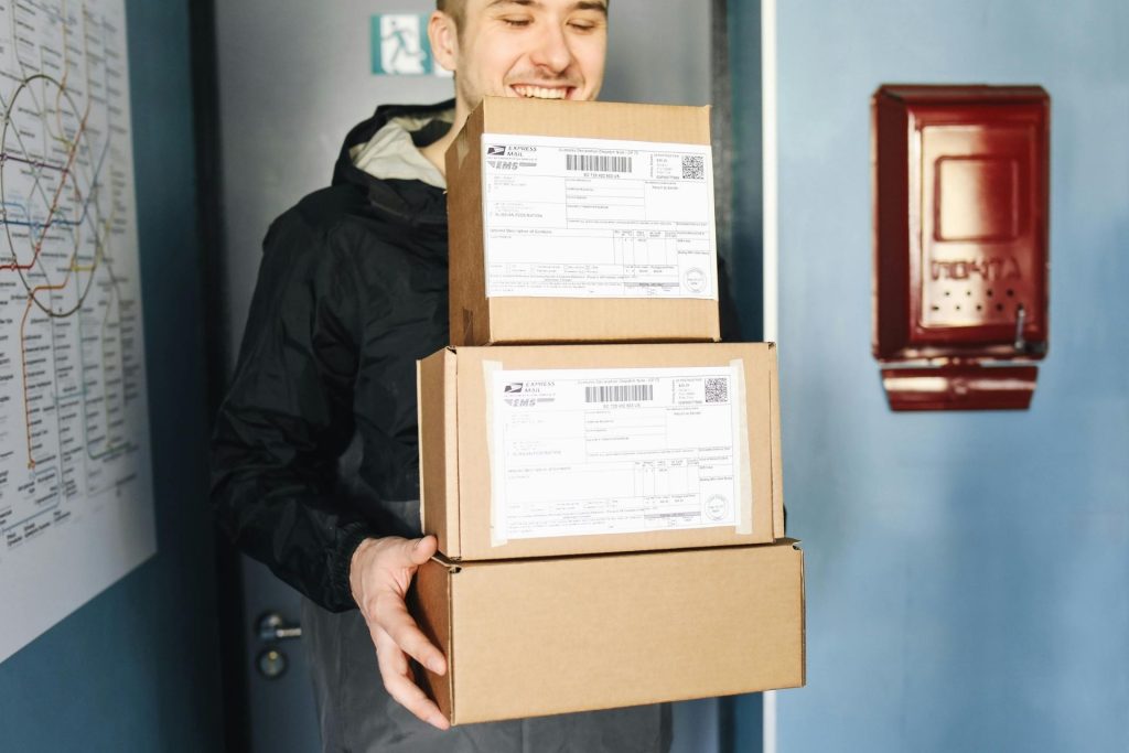 Man carrying three shipping boxes