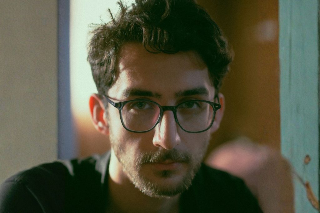 Man with heart-shaped face wearing round glasses