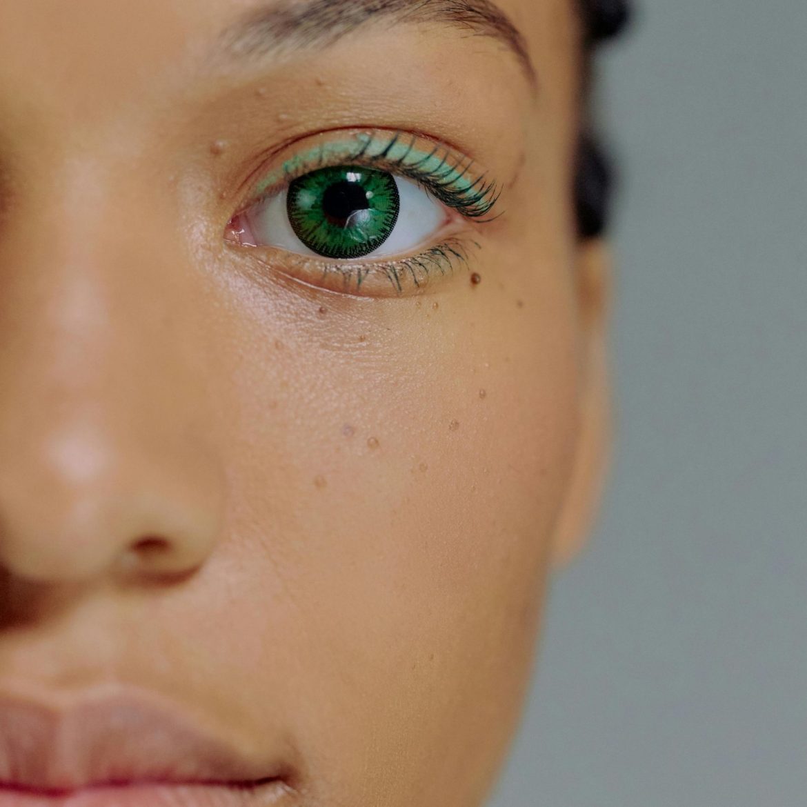 Close-up of a woman with bright green eyes