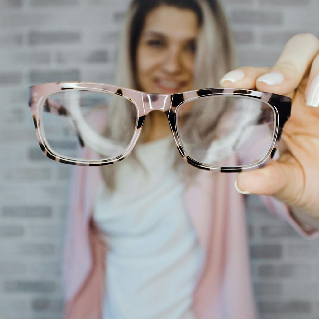 Woman holds up a pair of patterned glasses