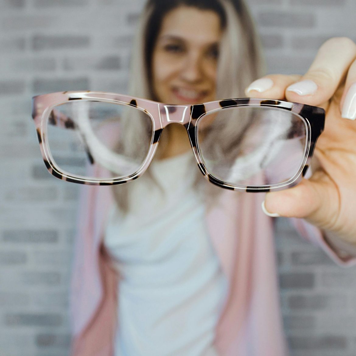 Woman holds up a pair of patterned glasses