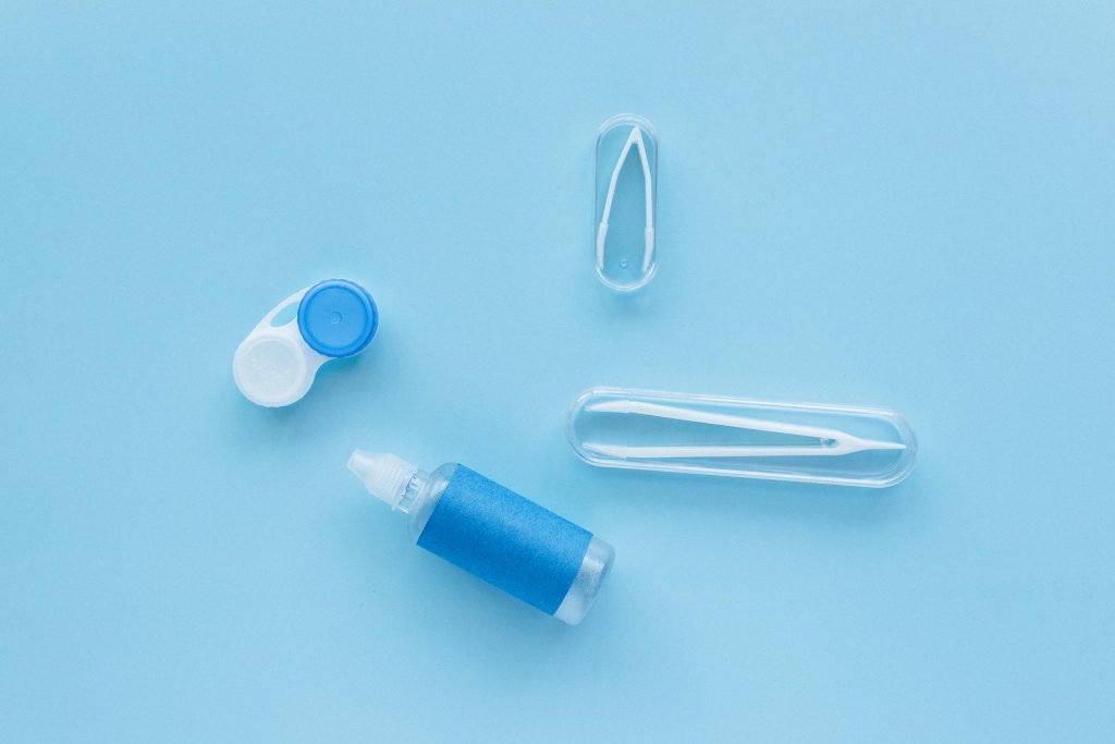 Contact lens case and solution on blue background