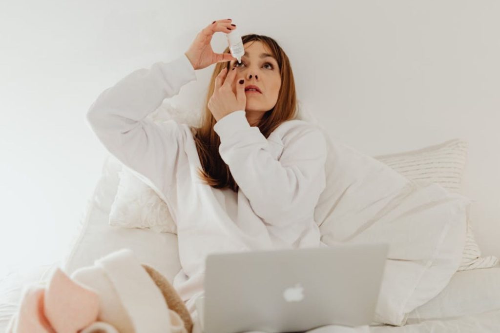 Woman putting in eyedrops