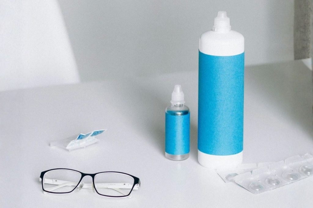 Contact lens solution and glasses on table