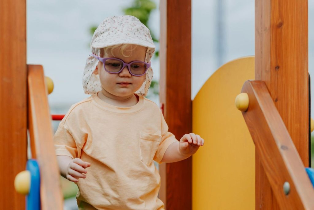 Toddler in purple glasses on playground