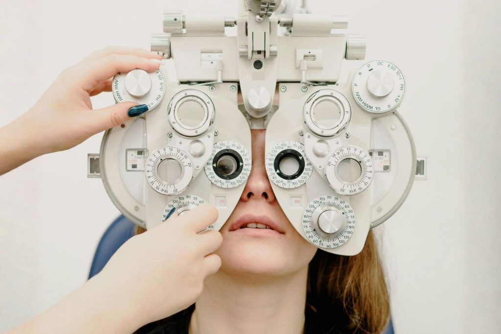 A woman getting an eye exam with a phoropter