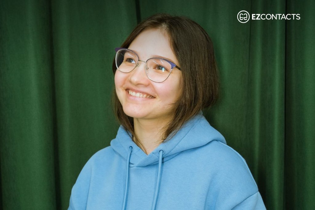 Woman wearing glasses against a green background