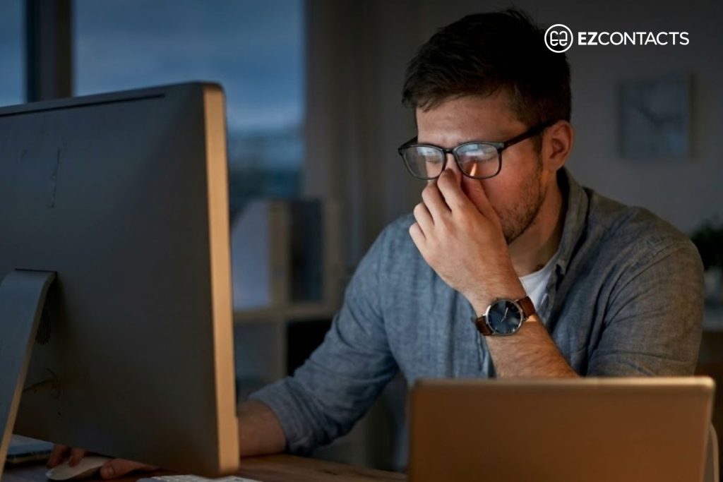 Man working at a computer and rubbing his eyes
