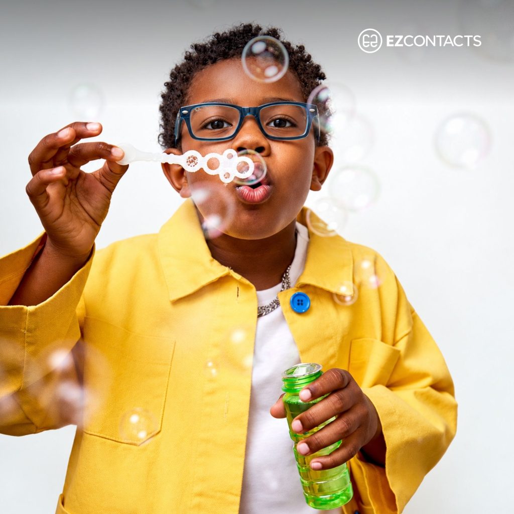 Young Boy Wearing Glasses and Blowing Bubbles
